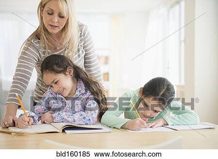 Caucasian mother helping daughters do homework View Large Photo Image Stock Photography - Caucasian mother helping daughters do homework. Fotosearch