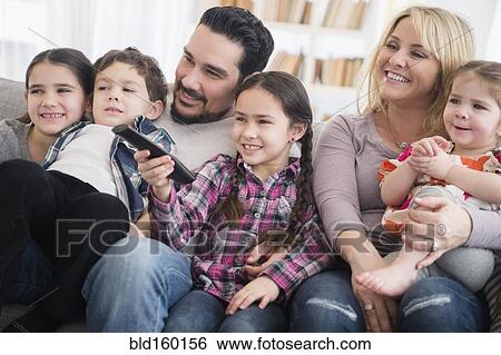 Stock Photograph - Caucasian parents and children smiling in living room. Fotosearch