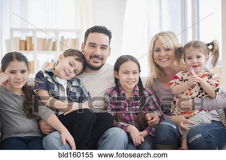 Stock Photography - Caucasian parents and children smiling in living room. Fotosearch