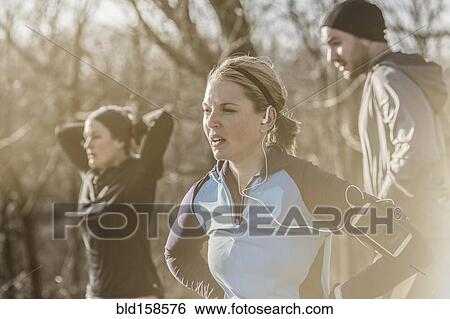 Stock Photograph - Caucasian runners resting in forest. Fotosearch