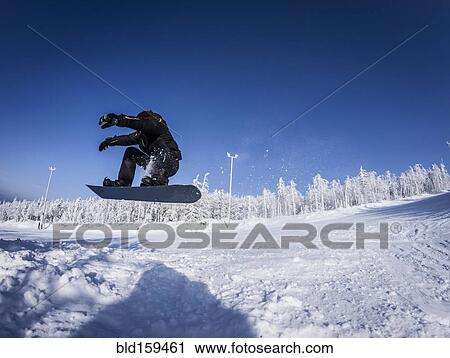 Caucasian snowboarder jumping on snowy slope View Large Photo Image Stock Image - Caucasian snowboarder jumping on snowy slope. Fotosearch