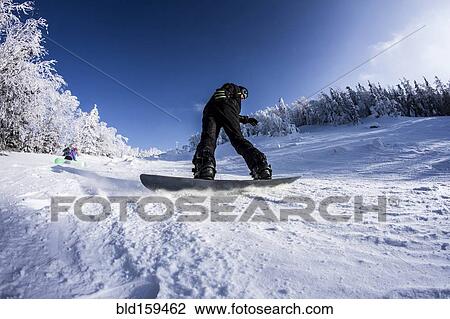 Stock Image - Caucasian snowboarder on snowy slope. Fotosearch