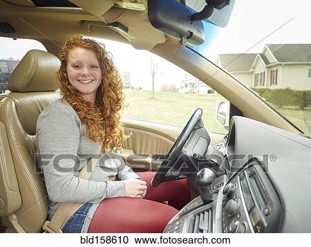Stock Image - Caucasian teenage girl driving car. Fotosearch