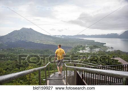 Stock Photo - Caucasian tourist admiring scenic view of jungle. Fotosearch