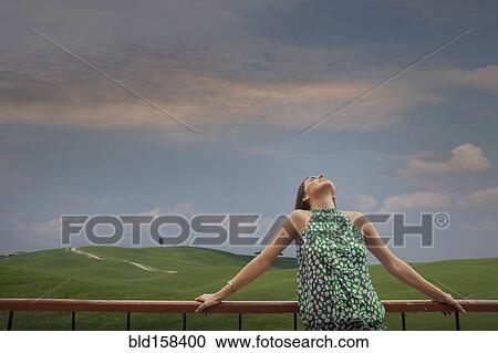 Caucasian woman admiring blue sky in rolling landscape View Large Photo Image Stock Image - Caucasian woman admiring blue sky in rolling landscape. Fotosearch