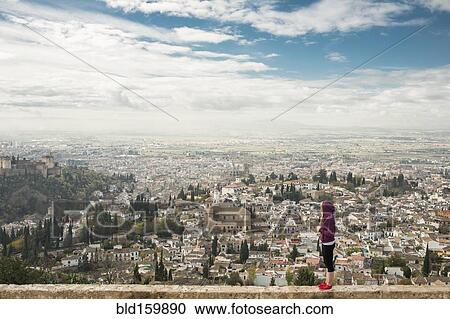 Stock Image - Caucasian woman admiring scenic view of cityscape, Granada, Spain. Fotosearch