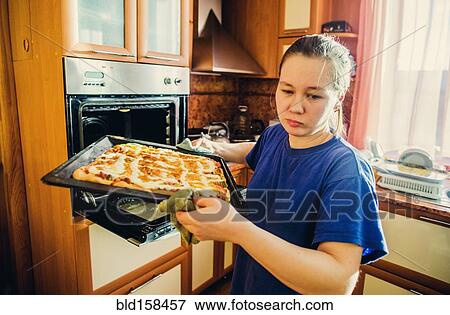 Stock Photo - Caucasian woman cooking in kitchen. Fotosearch