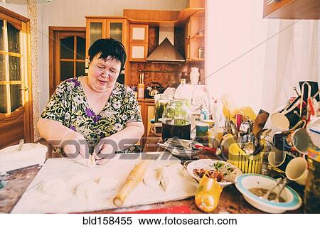 Stock Photography - Caucasian woman cooking in kitchen. Fotosearch