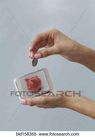 Caucasian woman depositing coin in cell phone piggy bank View Large Photo Image Stock Photography - Caucasian woman depositing coin in cell phone piggy bank. Fotosearch