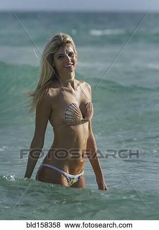 Caucasian woman in bikini standing in ocean waves View Large Photo Image Stock Photo - Caucasian woman in bikini standing in ocean waves. Fotosearch