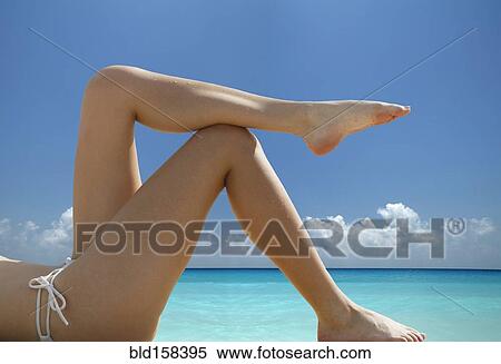 Stock Photography - Caucasian woman laying at ocean. Fotosearch