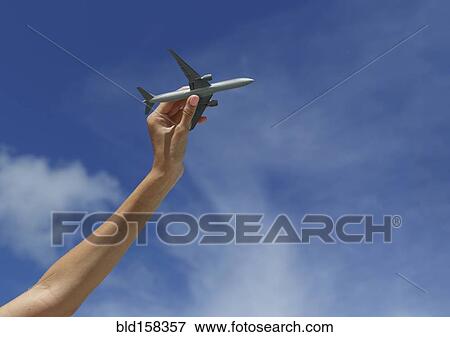 Caucasian woman playing with toy airplane under blue sky View Large Photo Image Stock Photo - Caucasian woman playing with toy airplane under blue sky. Fotosearch