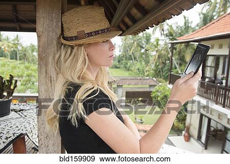 Caucasian woman reading digital tablet on balcony View Large Photo Image Stock Photo - Caucasian woman reading digital tablet on balcony. Fotosearch