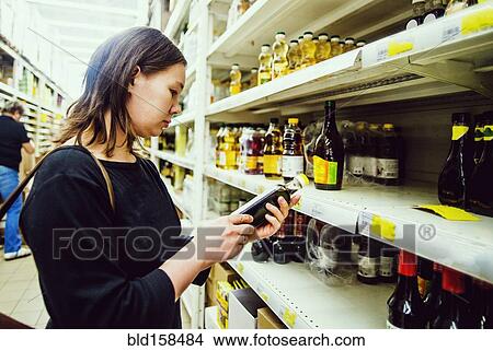 Picture - Caucasian woman shopping in grocery store. Fotosearch