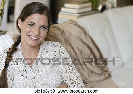 Stock Photo - Caucasian woman sitting on sofa. Fotosearch