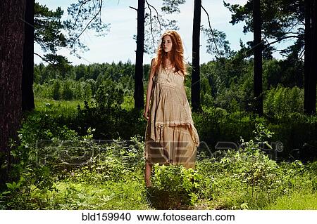 Stock Image - Caucasian woman standing in forest. Fotosearch