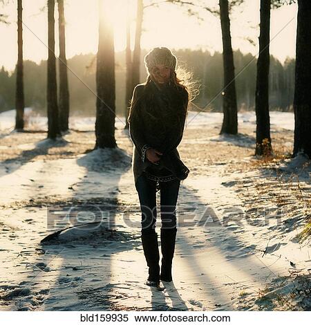 Stock Photography - Caucasian woman standing in snowy forest. Fotosearch