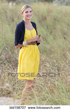 Caucasian woman standing in tall grass field View Large Photo Image Stock Photo - Caucasian woman standing in tall grass field. Fotosearch
