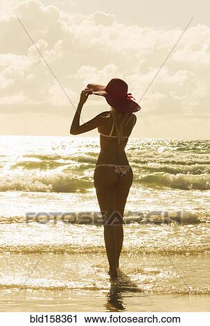 Stock Image - Caucasian woman standing on beach. Fotosearch