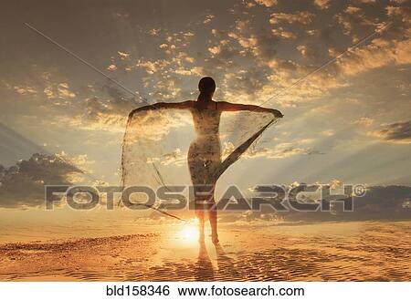 Caucasian woman under dramatic sunset sky View Large Photo Image Stock Photograph - Caucasian woman under dramatic sunset sky. Fotosearch
