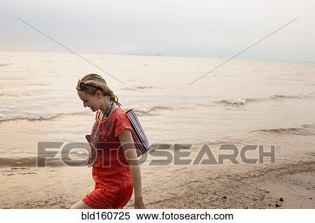 Stock Photography - Caucasian woman walking on beach. Fotosearch