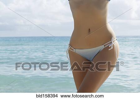 Picture - Caucasian woman wearing bikini in ocean. Fotosearch