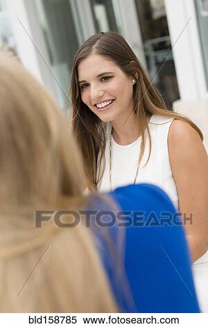 Stock Photography - Caucasian women sitting outdoors. Fotosearch