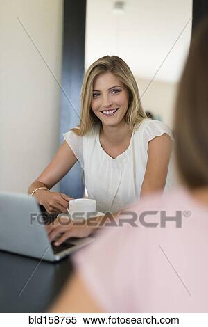 Caucasian women using laptop and drinking coffee View Large Photo Image Stock Photography - Caucasian women using laptop and drinking coffee. Fotosearch
