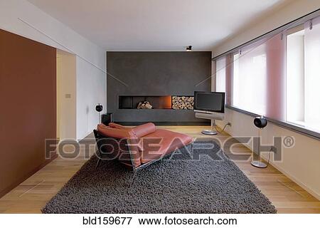 Stock Photo - Chaise longue, sofa, fireplace and rug in modern living room. Fotosearch
