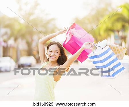 Chinese woman carrying shopping bags outdoors View Large Photo Image Stock Image - Chinese woman carrying shopping bags outdoors. Fotosearch
