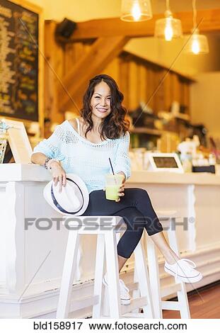 Chinese woman drinking smoothie in cafe View Large Photo Image Stock Photo - Chinese woman drinking smoothie in cafe. Fotosearch