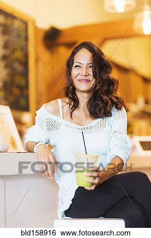 Chinese woman drinking smoothie in cafe View Large Photo Image Stock Photograph - Chinese woman drinking smoothie in cafe. Fotosearch