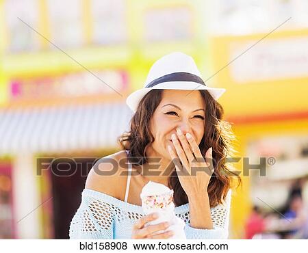Stock Photo - Chinese woman eating ice cream cone. Fotosearch