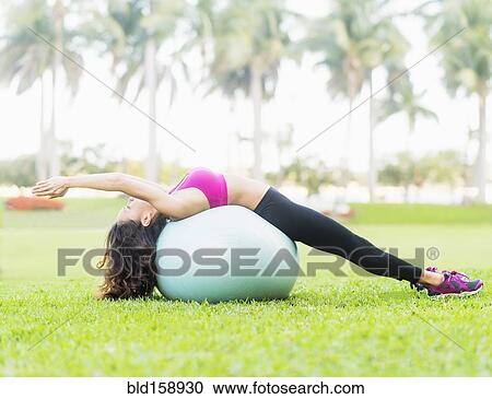 Chinese woman stretching on fitness ball in park View Large Photo Image Stock Image - Chinese woman stretching on fitness ball in park. Fotosearch