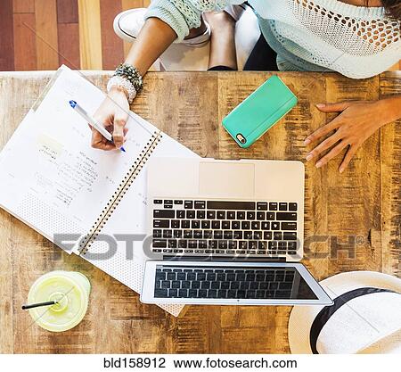 Stock Image - Chinese woman studying with laptop in cafe. Fotosearch