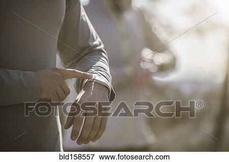 Close up of athlete checking sports watch View Large Photo Image Stock Photo - Close up of athlete checking sports watch. Fotosearch