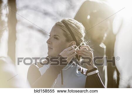 Close up of athlete putting on earbuds View Large Photo Image Stock Photography - Close up of athlete putting on earbuds. Fotosearch
