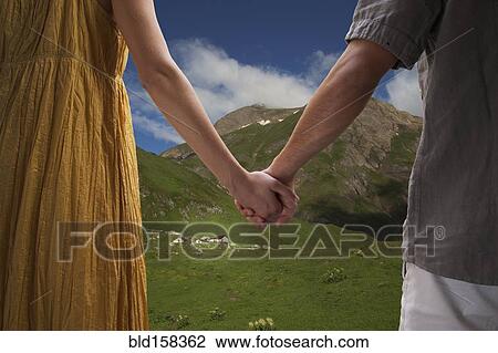 Close up of Caucasian couple holding hands on remote hillside View Large Photo Image Stock Image - Close up of Caucasian couple holding hands on remote hillside. Fotosearch