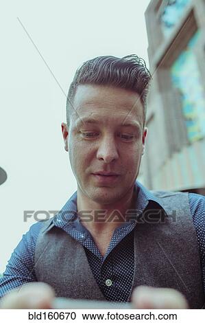 Stock Image - Close up of Caucasian man using cell phone. Fotosearch