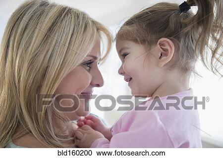 Stock Image - Close up of Caucasian mother holding daughter. Fotosearch