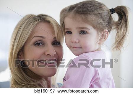 Stock Photo - Close up of Caucasian mother holding daughter. Fotosearch
