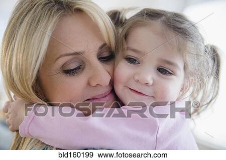 Stock Photo - Close up of Caucasian mother hugging daughter. Fotosearch