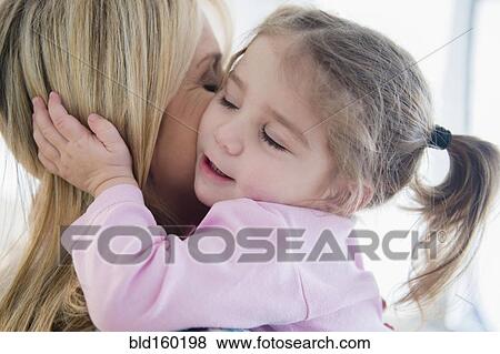 Stock Photo - Close up of Caucasian mother kissing daughter. Fotosearch