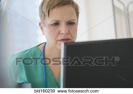 Stock Photo - Close up of Caucasian nurse using computer. Fotosearch