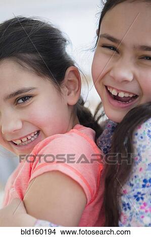 Picture - Close up of Caucasian sisters hugging. Fotosearch
