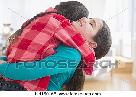 Stock Photo - Close up of Caucasian sisters hugging. Fotosearch
