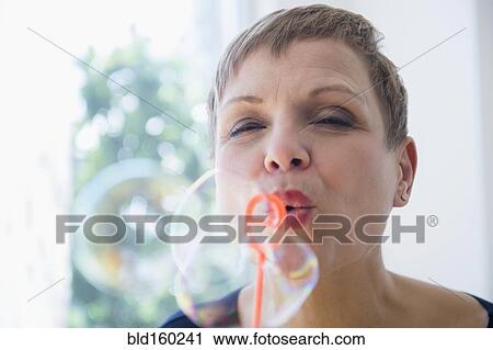 Close up of Caucasian woman blowing bubbles View Large Photo Image Stock Image - Close up of Caucasian woman blowing bubbles. Fotosearch