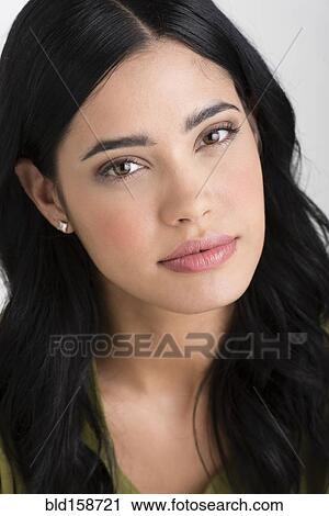 Stock Image - Close up of face of serious Hispanic woman. Fotosearch