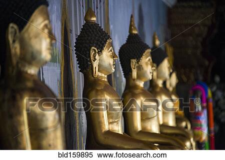 Stock Photography - Close up of golden Buddha statues in temple. Fotosearch