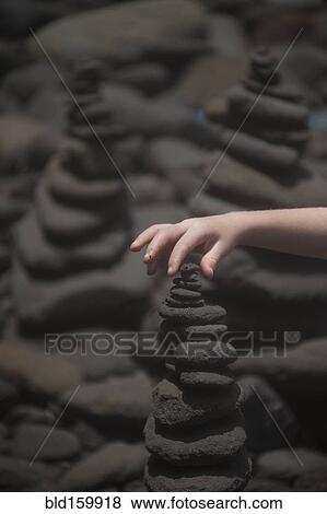 Close up of hand stacking rocks View Large Photo Image Stock Photo - Close up of hand stacking rocks. Fotosearch